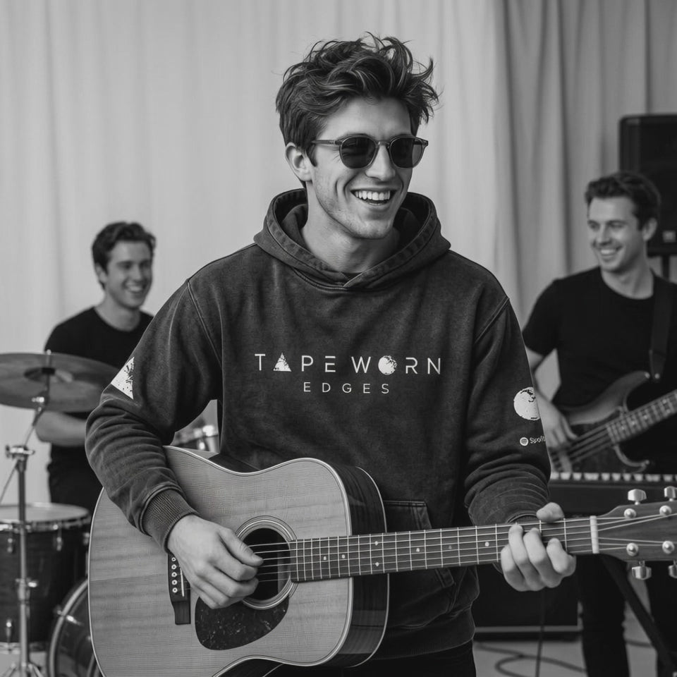 Smiling and playing guitar with his band playing quite a rocky song medium speed